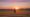 A person contemplates the end of a summer day, symbolizing the art of a graceful exit from a season and managing the Sunday Scaries.